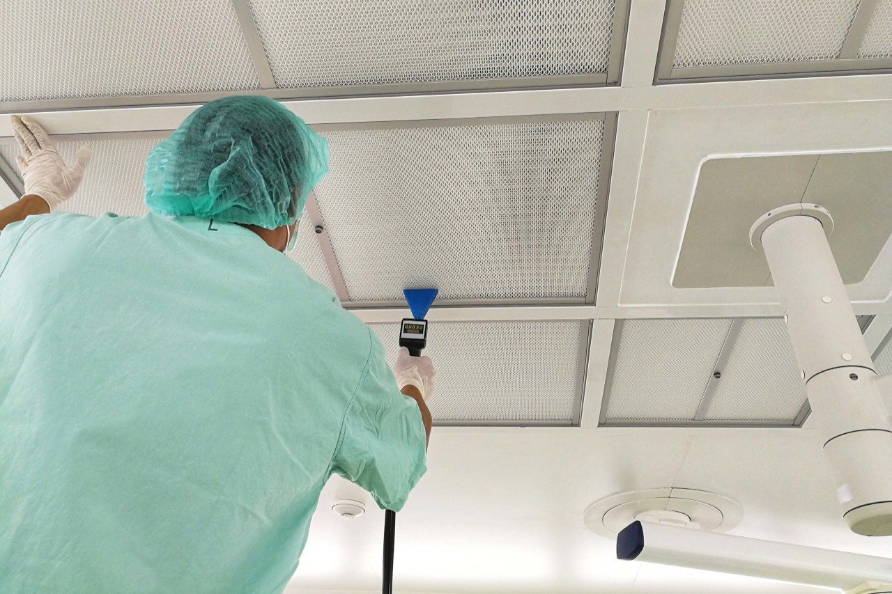 Técnico AZVIR realizando conteo de partículas ISO 14644-1 en sala limpia